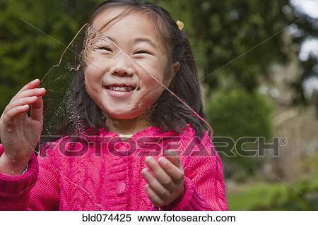 Stock Photography - Korean girl holding sheet of ice. Fotosearch