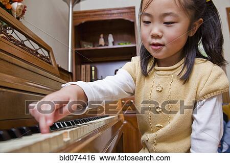 Stock Photograph - Korean girl playing piano. Fotosearch