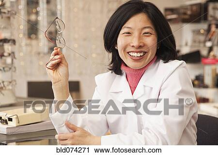 Korean optician holding eyeglasses View Large Photo Image Stock Image - Korean optician holding eyeglasses. Fotosearch