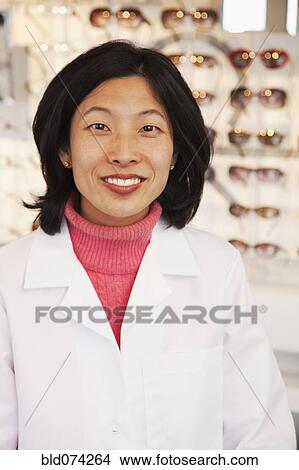 Picture - Korean optician standing in store. Fotosearch