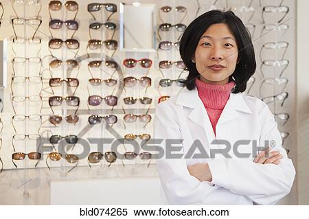 Stock Photography - Korean optician standing in store. Fotosearch
