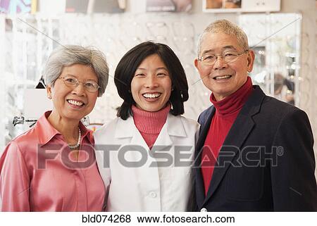 Stock Photo - Korean optician standing with customers. Fotosearch