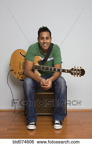 Mixed race man sitting with electric guitar View Large Photo Image Stock Photograph - Mixed race man sitting with electric guitar. Fotosearch