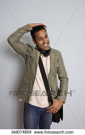 Picture - Mixed race man wearing headphones and bag. Fotosearch