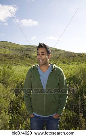 Stock Image - Mixed race standing in field. Fotosearch