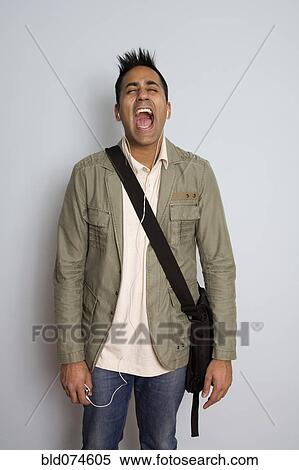 Shouting mixed race man wearing headphones and bag View Large Photo Image Stock Photography - Shouting mixed race man wearing headphones and bag. Fotosearch
