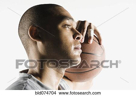 Picture - African man holding basketball. Fotosearch