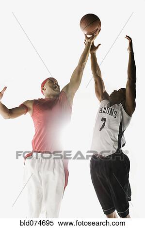 Stock Photography - African men jumping for basketball. Fotosearch