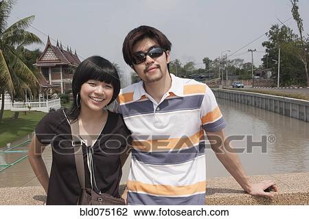 Stock Image - Asian couple outside of temple. Fotosearch