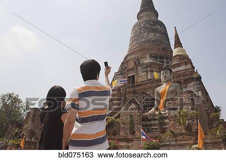 Stock Image - Asian couple photographing temple. Fotosearch