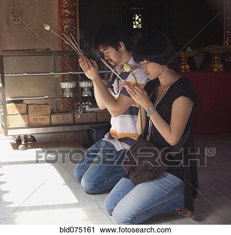 Asian couple praying at temple View Large Photo Image Stock Image - Asian couple praying at temple. Fotosearch