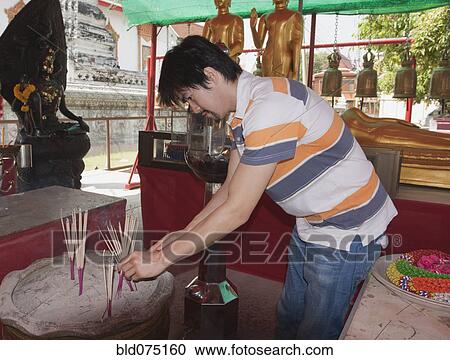Asian man placing prayer sticks in sand View Large Photo Image Stock Image - Asian man placing prayer sticks in sand. Fotosearch