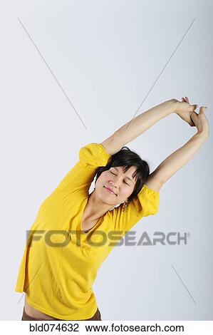 Filipino woman stretching arms overhead View Large Photo Image Stock Image - Filipino woman stretching arms overhead. Fotosearch