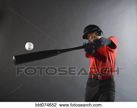 Stock Image - Mixed race baseball player swinging bat. Fotosearch