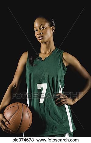 Stock Photo - Mixed race basketball player holding basketball. Fotosearch