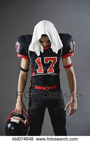 Mixed race football player looking down with towel on head View Large Photo Image Stock Photo - Mixed race football player looking down with towel on head. Fotosearch