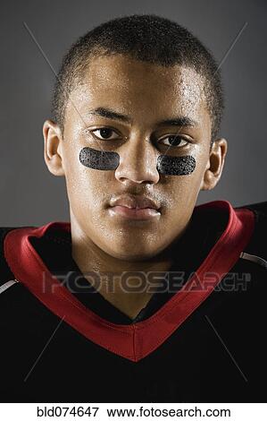 Stock Photo - Mixed race football player with face paint under eyes. Fotosearch