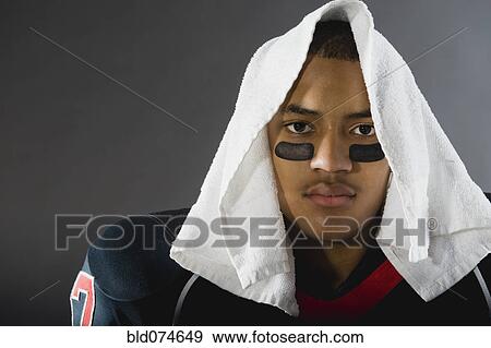 Stock Photo - Mixed race football player with towel on head. Fotosearch