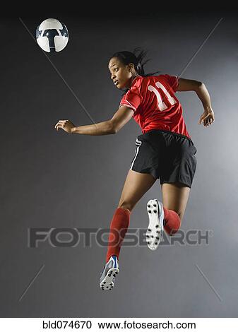 Mixed race soccer player in air with soccer ball View Large Photo Image Stock Image - Mixed race soccer player in air with soccer ball. Fotosearch