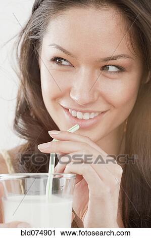 Mixed race woman drinking milk from straw View Large Photo Image Stock Image - Mixed race woman drinking milk from straw. Fotosearch