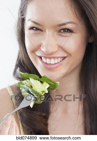 Mixed race woman eating salad View Large Photo Image Stock Photo - Mixed race woman eating salad. Fotosearch