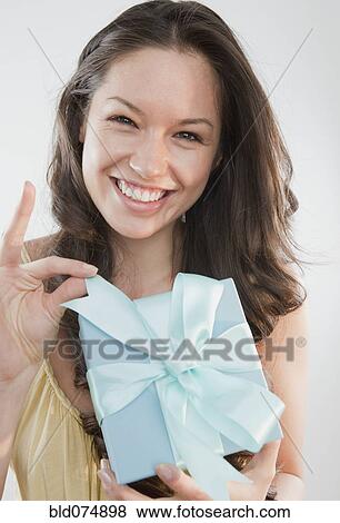 Stock Photo - Mixed race woman holding gift. Fotosearch
