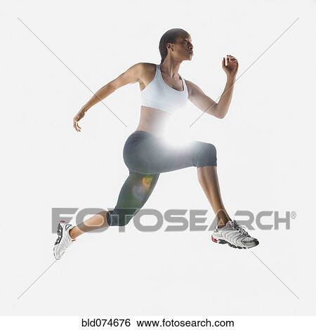 Stock Photograph - Mixed race woman jumping in mid-air. Fotosearch