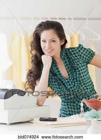 Mixed race woman leaning on cash register View Large Photo Image Picture - Mixed race woman leaning on cash register. Fotosearch