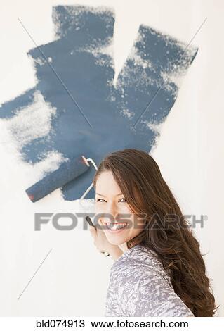 Mixed race woman painting wall View Large Photo Image Stock Image - Mixed race woman painting wall. Fotosearch