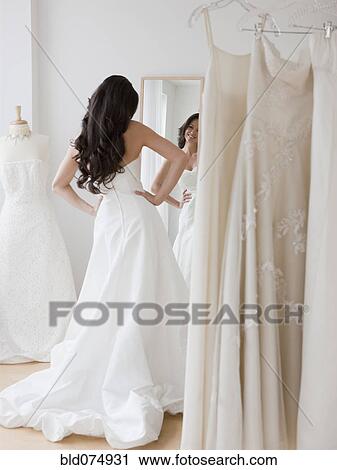 Mixed race woman trying on wedding dresses View Large Photo Image Stock Image - Mixed race woman trying on wedding dresses. Fotosearch