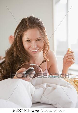 Stock Photograph - Mixed race woman watching football on television. Fotosearch