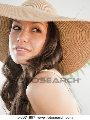 Stock Photo - Mixed race woman wearing sun hat. Fotosearch