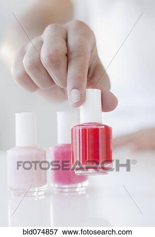 Woman choosing red fingernail polish bottle View Large Photo Image Stock Photo - Woman choosing red fingernail polish bottle. Fotosearch