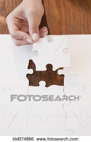 Stock Photograph - Woman completing jigsaw puzzle. Fotosearch