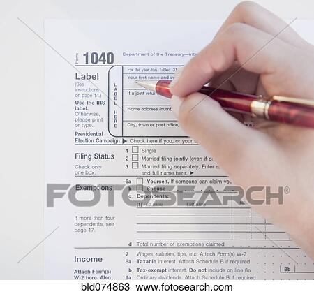 Stock Image - Woman completing tax form. Fotosearch