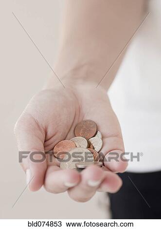 Stock Image - Woman holding coins. Fotosearch