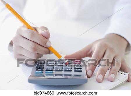 Stock Image - Woman using calculator. Fotosearch