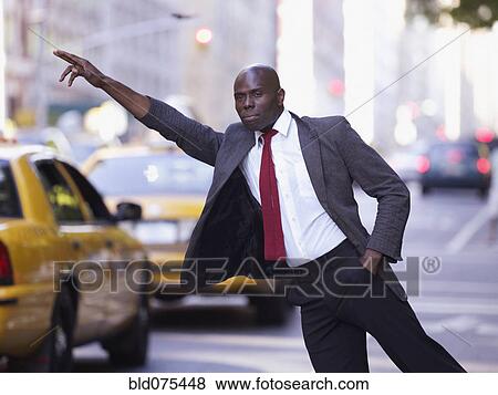 Stock Photo - African businessman hailing taxi. Fotosearch