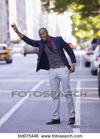 Stock Photograph - African businessman hailing taxi. Fotosearch