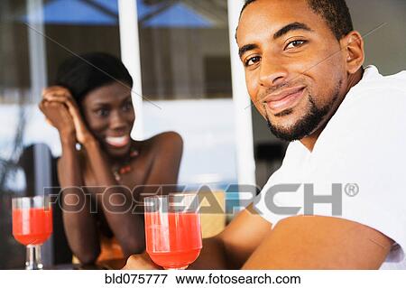 African couple drinking cocktails on patio View Large Photo Image Stock Photo - African couple drinking cocktails on patio. Fotosearch