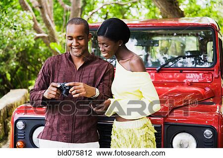 African couple looking down at digital camera View Large Photo Image Stock Image - African couple looking down at digital camera. Fotosearch