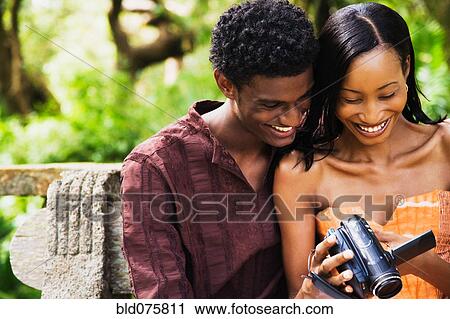 African couple looking down at video camera View Large Photo Image Stock Image - African couple looking down at video camera. Fotosearch