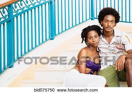 Stock Image - African couple sitting on deck. Fotosearch