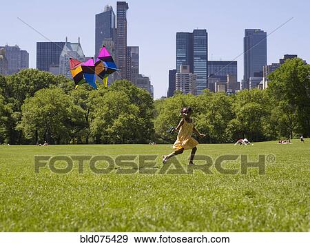 African girl flying kite in park View Large Photo Image Stock Photo - African girl flying kite in park. Fotosearch