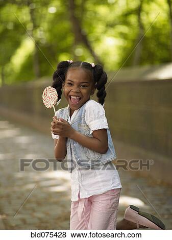 Stock Photo - African girl holding lollipop. Fotosearch