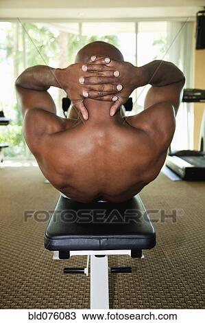 Stock Image - African man doing sit-ups. Fotosearch