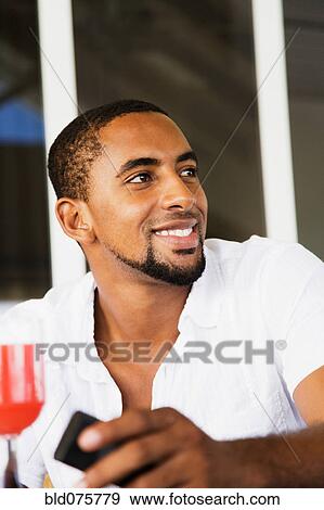 African man holding cell phone View Large Photo Image Stock Photo - African man holding cell phone. Fotosearch