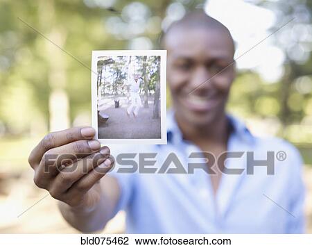 African man holding photograph View Large Photo Image Stock Image - African man holding photograph. Fotosearch