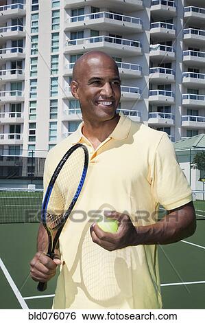 African man holding tennis ball and racket View Large Photo Image Stock Photograph - African man holding tennis ball and racket. Fotosearch