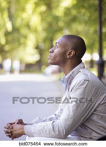 African man looking up with hands clasped View Large Photo Image Picture - African man looking up with hands clasped. Fotosearch